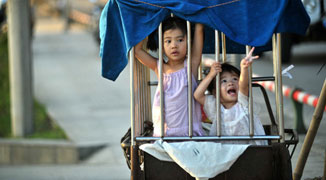 Liuzhou Woman Spotted Carrying Granddaughters to School in Cage