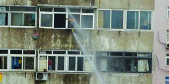 Fire Fighters Use Water Cannon to Blast Suicidal Man through Window